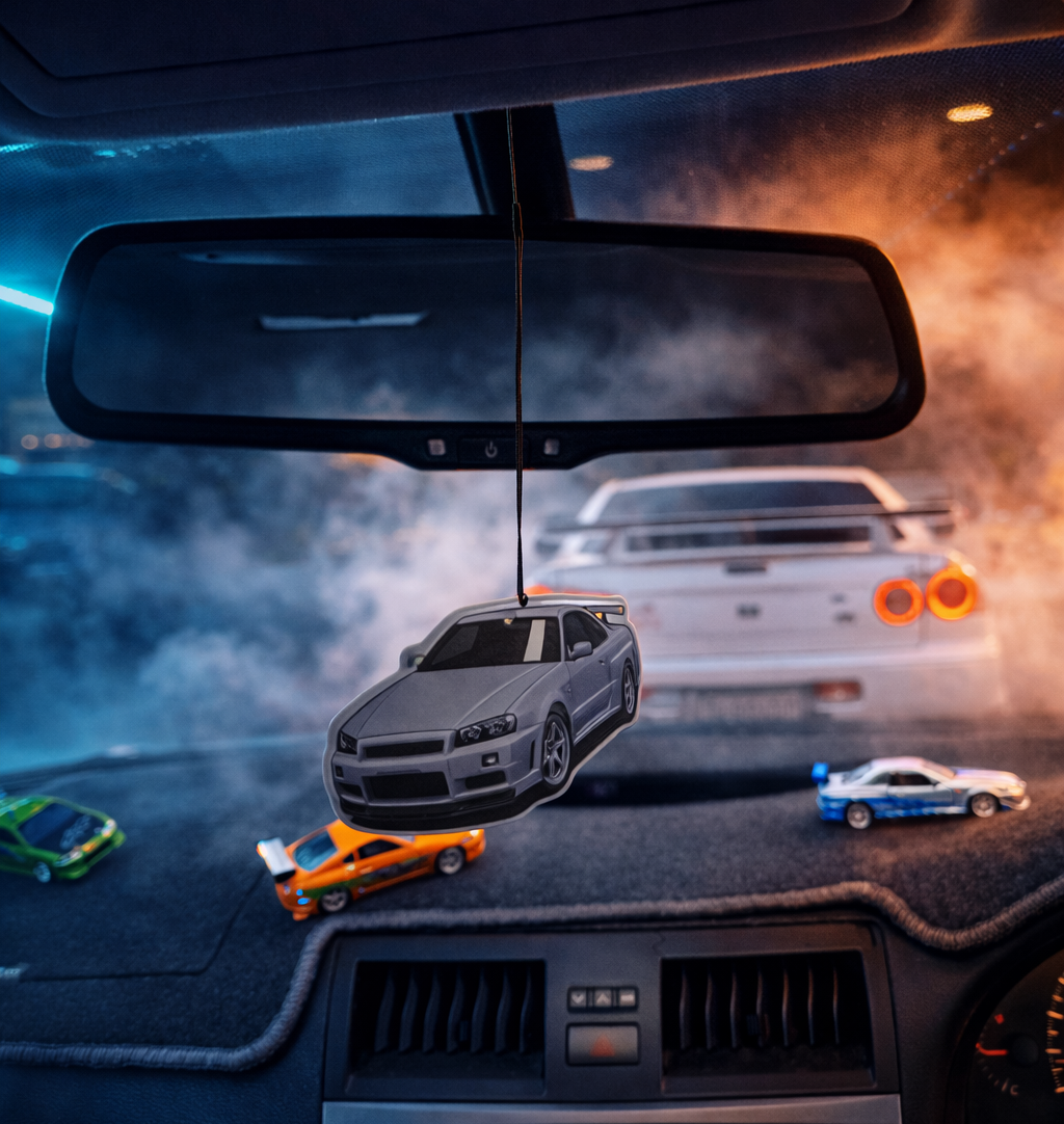 Car interior with a rearview mirror, dashboard, and toy cars.